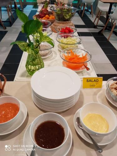 a table topped with plates and bowls of food at The Qube fifty Hotel in Bangkok
