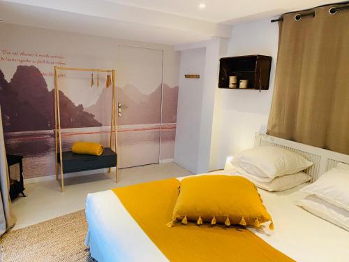 1 dormitorio con cama con sábanas amarillas y ducha en Le 19, en Séné