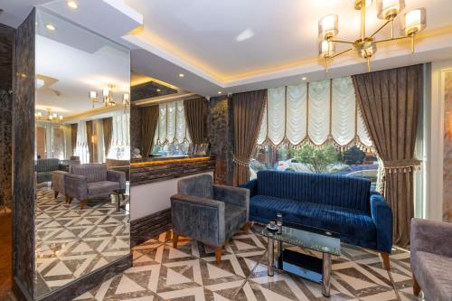 a waiting room with a blue couch and chairs at Hotel Yesilpark in Istanbul