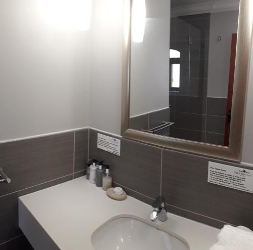 a bathroom with a sink and a mirror at Villa Tuscana in Port Elizabeth