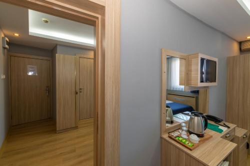 a small room with a kitchen and a room with a bed at Hotel Yesilpark in Istanbul