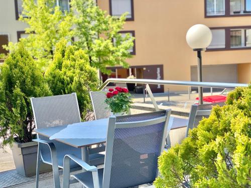 Hinwil的住宿－Hotel Hirschen Hinwil，阳台上配有蓝色的桌椅