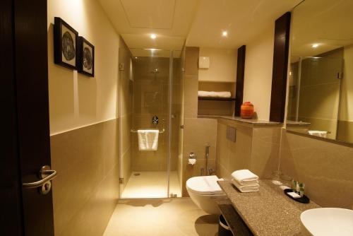 a bathroom with a toilet and a sink and a shower at Comfort Inn Dehradun in Dehradun