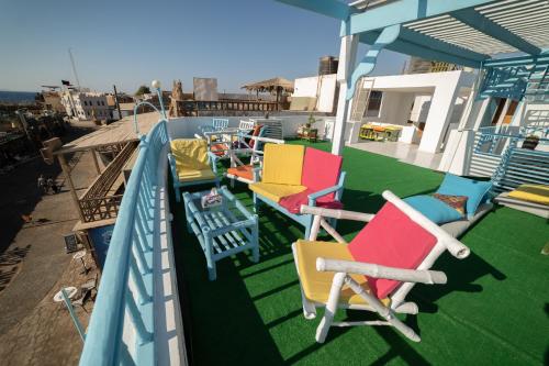 a balcony with colorful chairs and tables on a ship at Bamboo House Hotel Dahab in Dahab