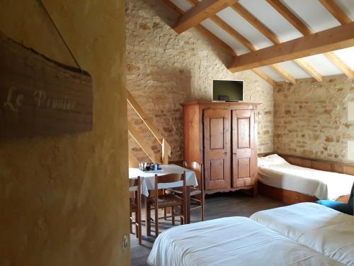 a room with a table and a room with two beds at La SERPAUDERIE in Saint-André-de-Lidon