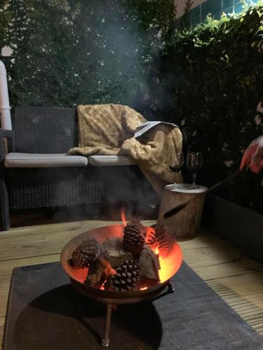 a fire pit with fruits in it on a patio at Bem Lembrados Apartment in Cascais