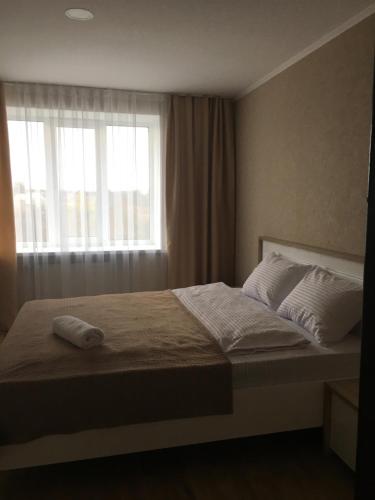 a bedroom with a large bed with a window at Hotel Elegia in Trostyanets