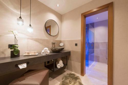 ein Bad mit einem Waschbecken und einem Spiegel in der Unterkunft Hotel Garni Mirabell in Ischgl