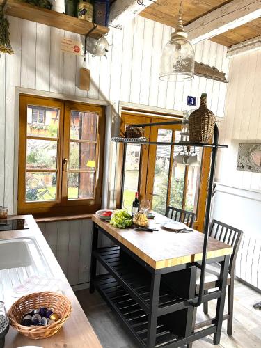a kitchen with a island with a table in it at La Ferme de Marie in Rangen