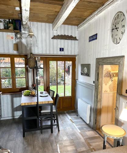 a kitchen with a table and a clock on the wall at La Ferme de Marie in Rangen