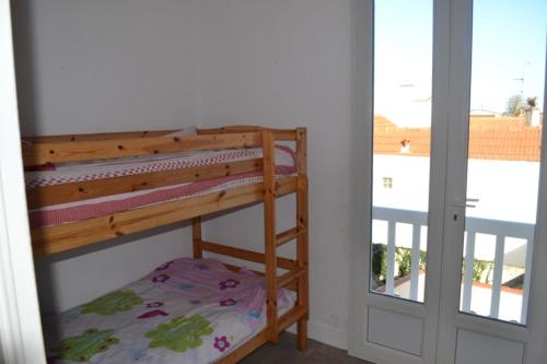 Etagenbett in einem Zimmer mit Fenster in der Unterkunft Maison 300 m de la plage in Châtelaillon-Plage