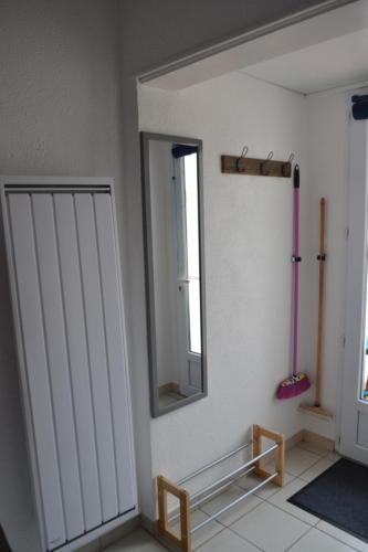 Dieses weiße Zimmer verfügt über einen Spiegel und ein Fenster. in der Unterkunft Maison 300 m de la plage in Châtelaillon-Plage