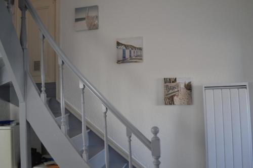 a staircase with three pictures on the wall at Maison 300 m de la plage in Châtelaillon-Plage