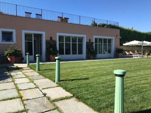 a house with green poles in front of a yard at Villa Bricco dei Cogni in La Morra