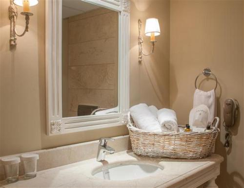 La salle de bains est pourvue d'un lavabo et d'un panier de serviettes. dans l'établissement Hotel Carina, à Kusadası