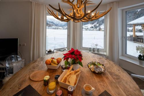 un tavolo con pane e frutta con un lampadario a braccio di Apartmenthaus Mountainvista a Kleinarl