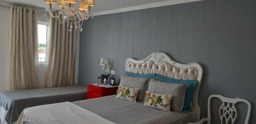 um quarto com uma cama e um lustre em Pousada Cris Garden Bed&Breakfast em Foz do Iguaçu