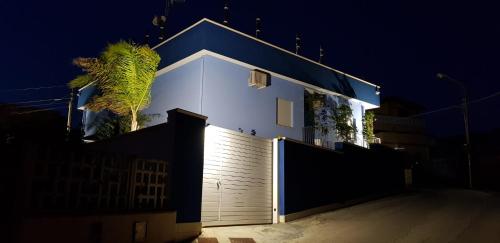 uma casa com um telhado azul e uma cerca em Scala dei Turchi Beach house em Realmonte