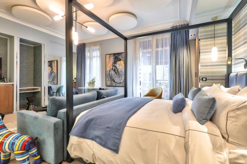 a bedroom with a large bed and a couch at Hotel 33 Marbeuf in Paris