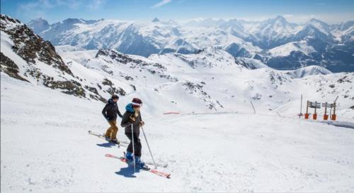 dos personas en una pista de esquí en una montaña en Appt 43 m2 Station Auris en Oisans - Alpes d huez, en Auris