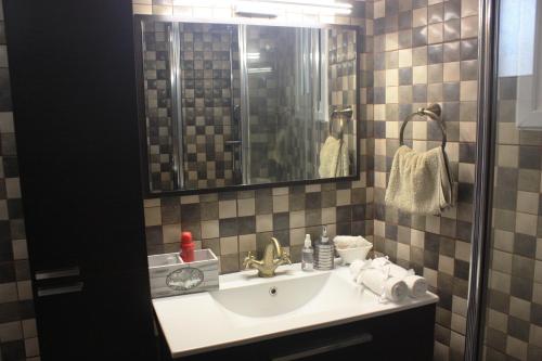 een badkamer met een wastafel en een spiegel bij Laoni Guest House in Moutoullas, Marathasa in Limassol