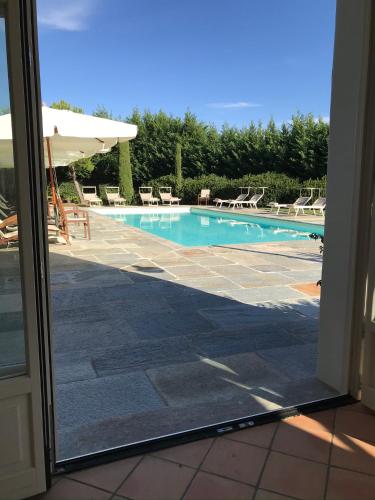 a view of a swimming pool through a sliding glass door at Villa Bricco dei Cogni in La Morra