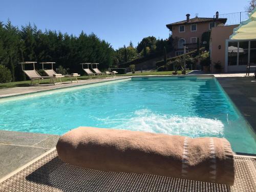 a swimming pool with a towel on the edge at Villa Bricco dei Cogni in La Morra