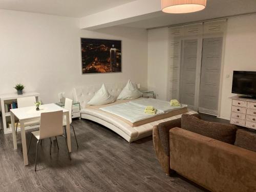 een slaapkamer met een bed, een tafel en een bank bij Appartements am Hafen in Zwenkau