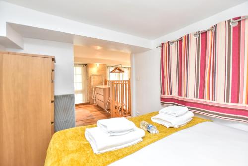 une chambre avec un lit avec deux serviettes dessus dans l'établissement Splendid duplex - 1BR-2P - Notre Dame-Île St-Louis, à Paris