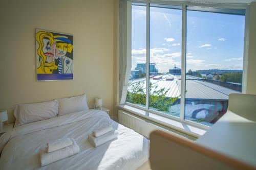 a bedroom with a white bed and a large window at Royal Stuart Lane - Townhouse by the Bay with Parking in Cardiff