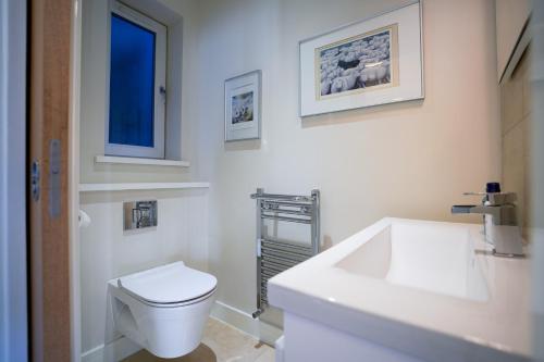 a white bathroom with a toilet and a sink at Royal Stuart Lane - Townhouse by the Bay with Parking in Cardiff