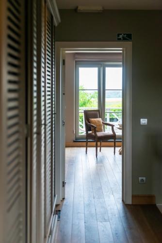 a living room with a chair and a window at B&B La Cereza in Oudenaarde