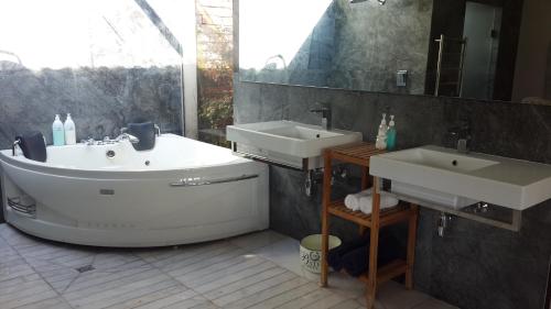a bathroom with two sinks and a bath tub at Slaley Country House in Stellenbosch
