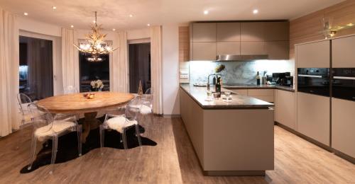a kitchen with a wooden table and a dining room at Apartmenthaus Mountainvista in Kleinarl