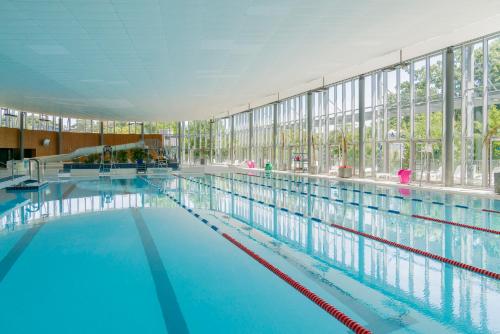 une grande piscine avec de l'eau bleue dans un immeuble dans l'établissement Nantes Camping Le Petit Port, à Nantes