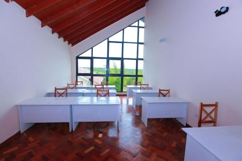 a room with tables and chairs and a large window at Mtoni Resort, Naro moru in Naro Moru