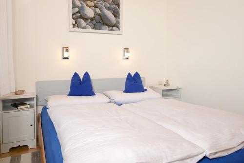 a bedroom with two beds with blue pillows on them at Ferienwohnung am Hauchen in Reit im Winkl