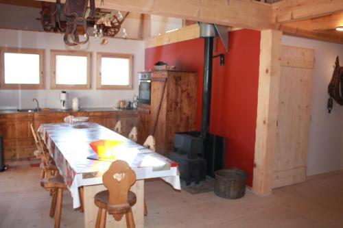 une cuisine avec une table et des chaises dans une pièce dans l'établissement La Case, à Abondance