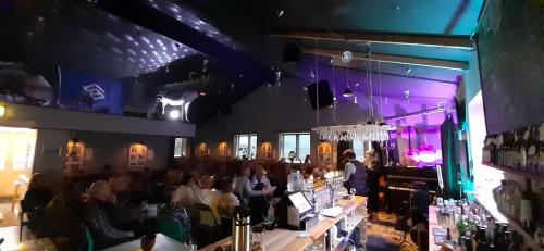 una multitud de personas sentadas en un bar en un restaurante en Tehúsið Hostel en Egilsstadir