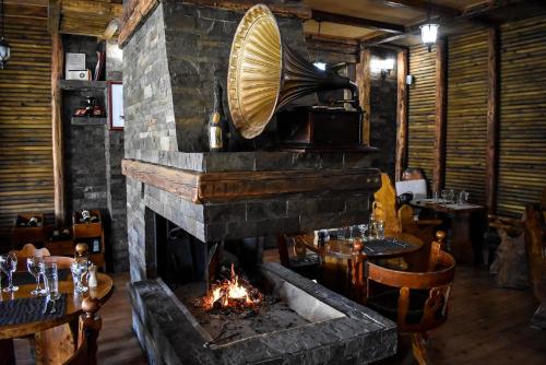 a stone fireplace in a restaurant with tables and chairs at Vila Prezident in Sremski Karlovci