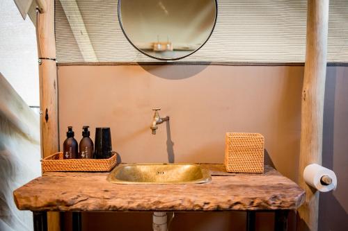 lavabo con espejo en una encimera de madera en Bundox Explorer Camp en Hoedspruit