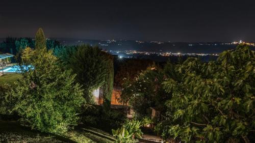 a night view of a house with trees at Villa Bricco dei Cogni in La Morra