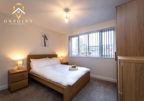 um quarto com uma cama e uma grande janela em OnPoint - Spacious 2 Bed Apt - FREE Parking em Reading
