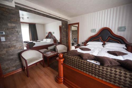 a bedroom with a large bed and a desk and a bedroom with a bedsenal at Vila Prezident in Sremski Karlovci