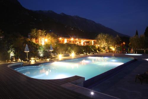 a large swimming pool at night with a building in the background at Hotel Sailing Center in Malcesine
