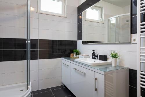 a white bathroom with a sink and a shower at Apartments Tanita in Podstrana