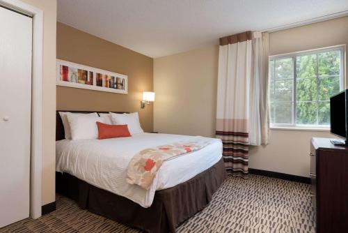 a hotel room with a bed and a window at MainStay Suites Chicago Schaumburg in Schaumburg