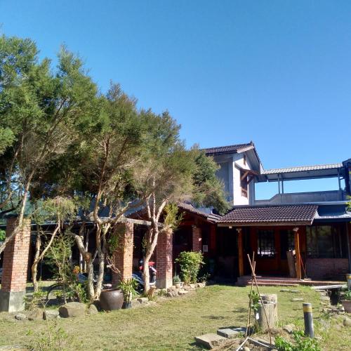 a house with trees in front of it at Jiji Village Villa B&B in Lugu Lake