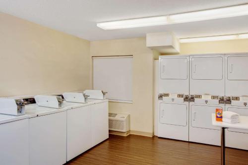 a laundry room with white cabinets and washing machines at MainStay Suites Greensboro in Greensboro