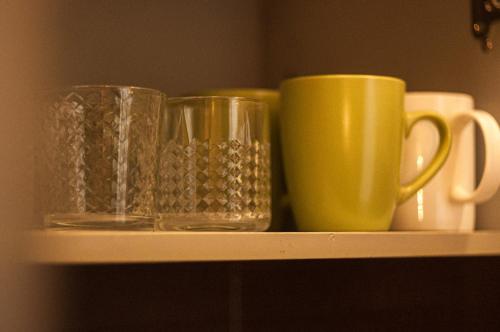 two glass cups sitting on a shelf at Kyiv Center Romantic Apartment in Kyiv
